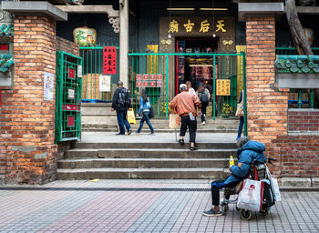 Rear view of people walking on sidewalk