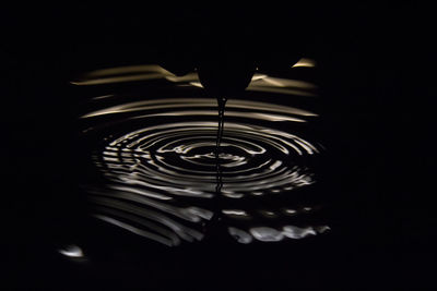 Close-up of water flowing over black background