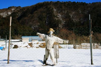 Statue against snow covered trees