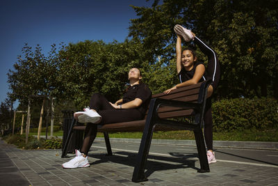 Mom and daughter in sportswear on a sunny summer day on the embankment in the park 