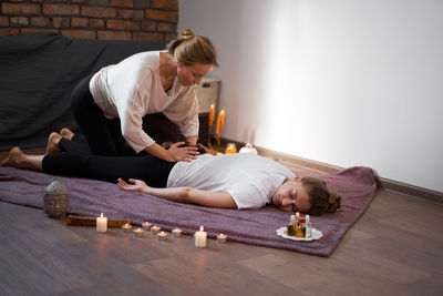 Woman lying down while sitting on floor