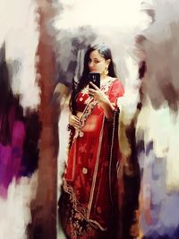 Full length portrait of young woman standing outdoors