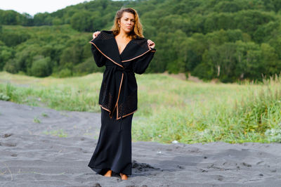 Portrait of young woman standing on road