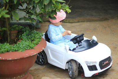 Side view of a woman sitting by car