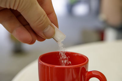 Close-up of hand pouring drink in cup