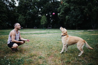 Full length of man playing with dog