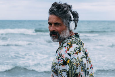 Middle-aged man with headphones and casual clothes on the beach person