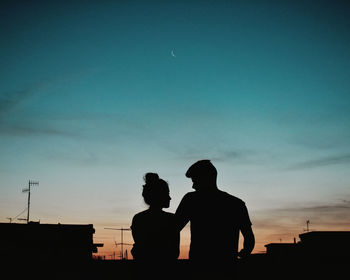 Silhouette men against blue sky at sunset