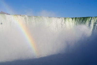 Low angle view of rainbow over sea against sky