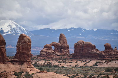 Rock formations on landscape against cloudy sky