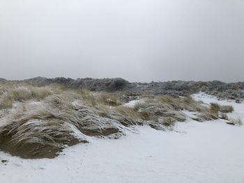 Scenic view of snow covered land against clear sky
