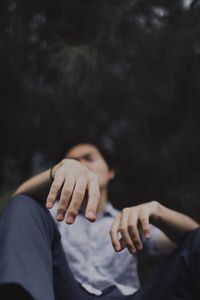 Low angle view of thoughtful man sitting by tree