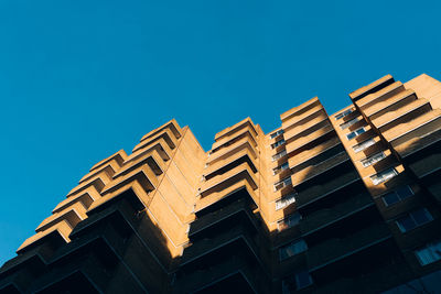 Low angle view of modern buildings against clear blue sky