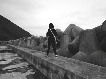 People standing on rock against sky