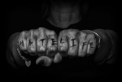 Close-up of fists with text against black background