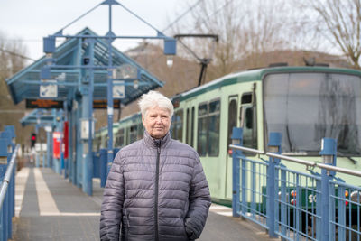 Portrait of woman standing at railroad station platform