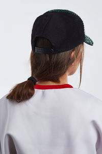 Rear view of woman wearing hat against white background