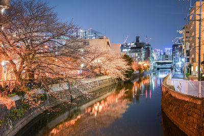 River amidst illuminated buildings in city at night