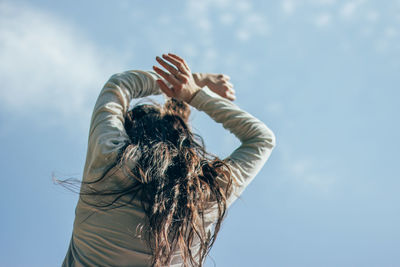 Rear view of woman standing against sky