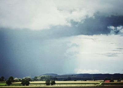 Scenic view of field against cloudy sky