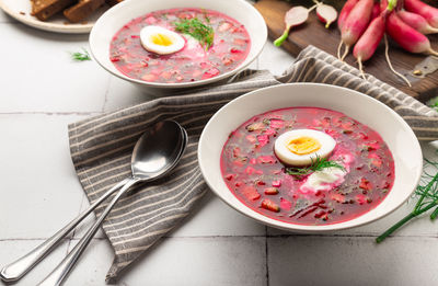 Summer cold beetroot soup with sour cream and egg on white tile background. russian cuisine. 