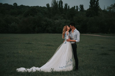 Couple kissing while standing on grass