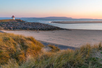 Scenic view of beach against sky during sunset