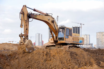 Yellow excavator during earthworks at construction site. backhoe digging the ground