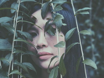 Close-up of young woman with plants