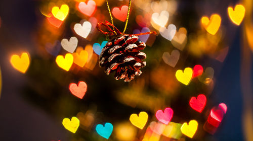 Close-up of christmas lights hanging at night