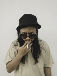 Portrait of young man standing against wall