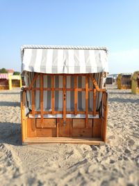 Chairs on beach against sky on sunny day