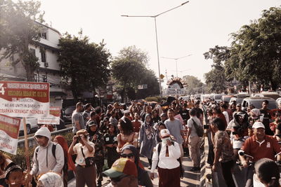 Group of people on street in city against sky