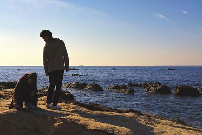 Man standing on beach against clear sky