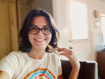 Portrait of smiling young woman sitting at home