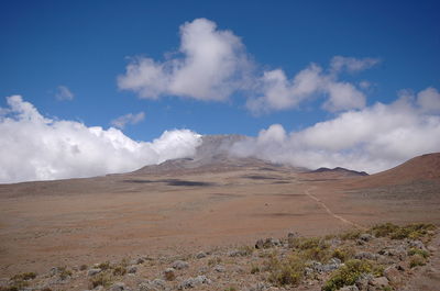 Scenic view of desert against blue sky