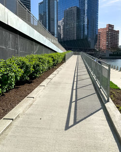 Footpath amidst buildings in city against sky