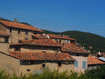 Houses in town against clear blue sky