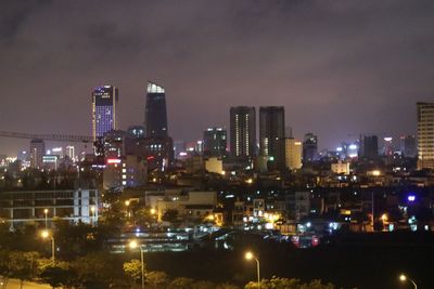 Illuminated cityscape against sky at night