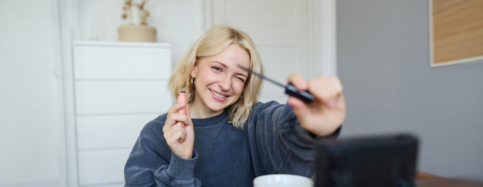 Young woman using mobile phone at home