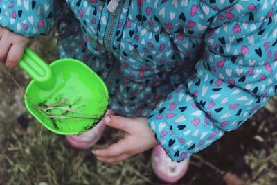 Low section of girl holding toy while standing outdoors