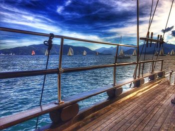 Bridge over sea against cloudy sky