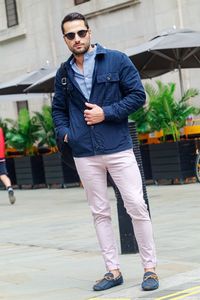Full length of young man standing on footpath
