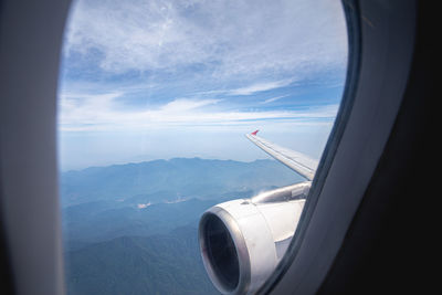 Airplane flying over mountains seen through window