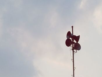 Low angle view of weather vane against sky