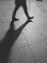 Low section of man standing on tiled floor