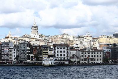 Buildings in city against cloudy sky