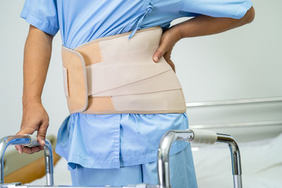 Midsection of woman holding wheelchair