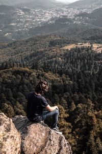 Man sitting on rock looking at mountains