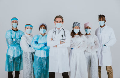 Portrait of doctors wearing mask against white background